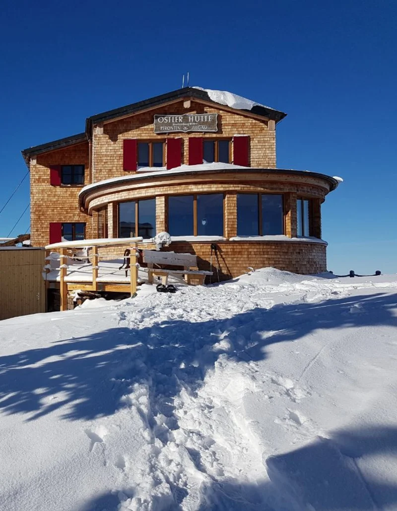 Die Ostlerhütte inmitten einer schneebedeckten Berglandschaft.