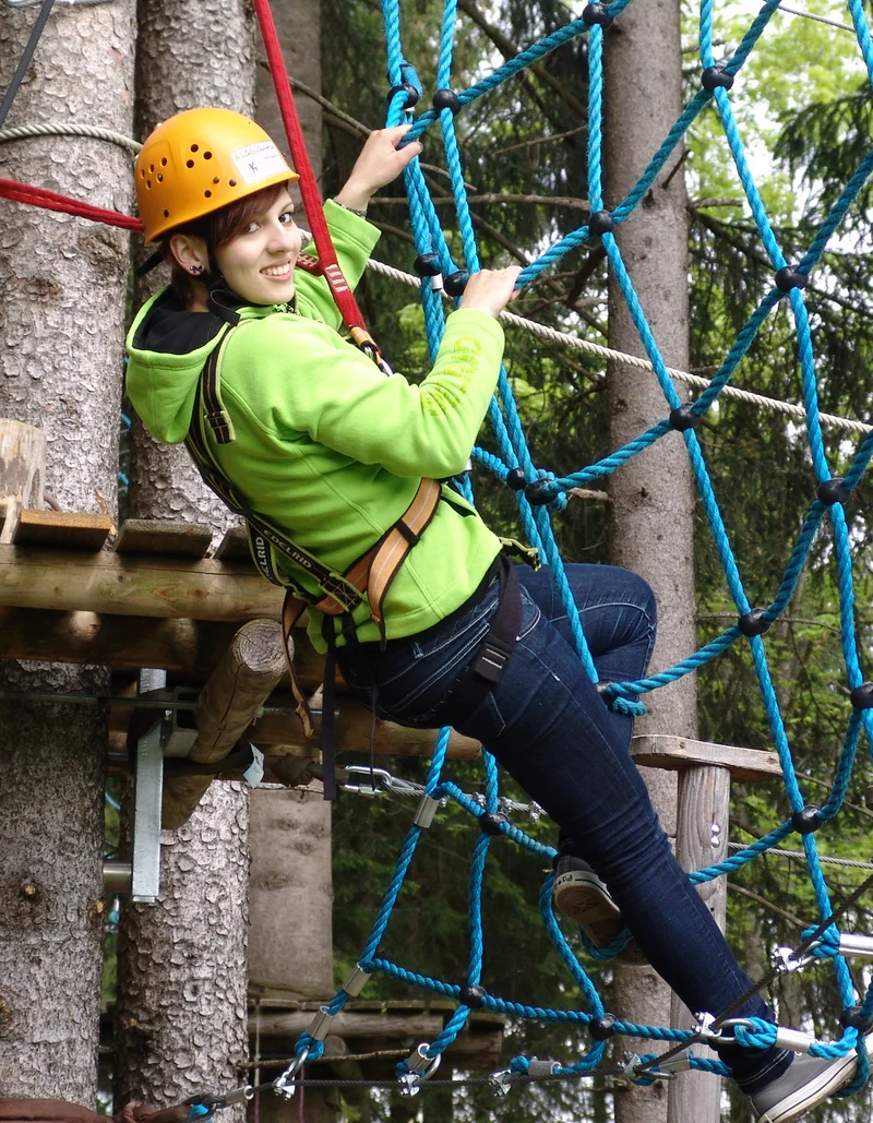 Kletterspaß für die ganze Familie Eine Kletterin im Waldseilgarten in Pfronten.