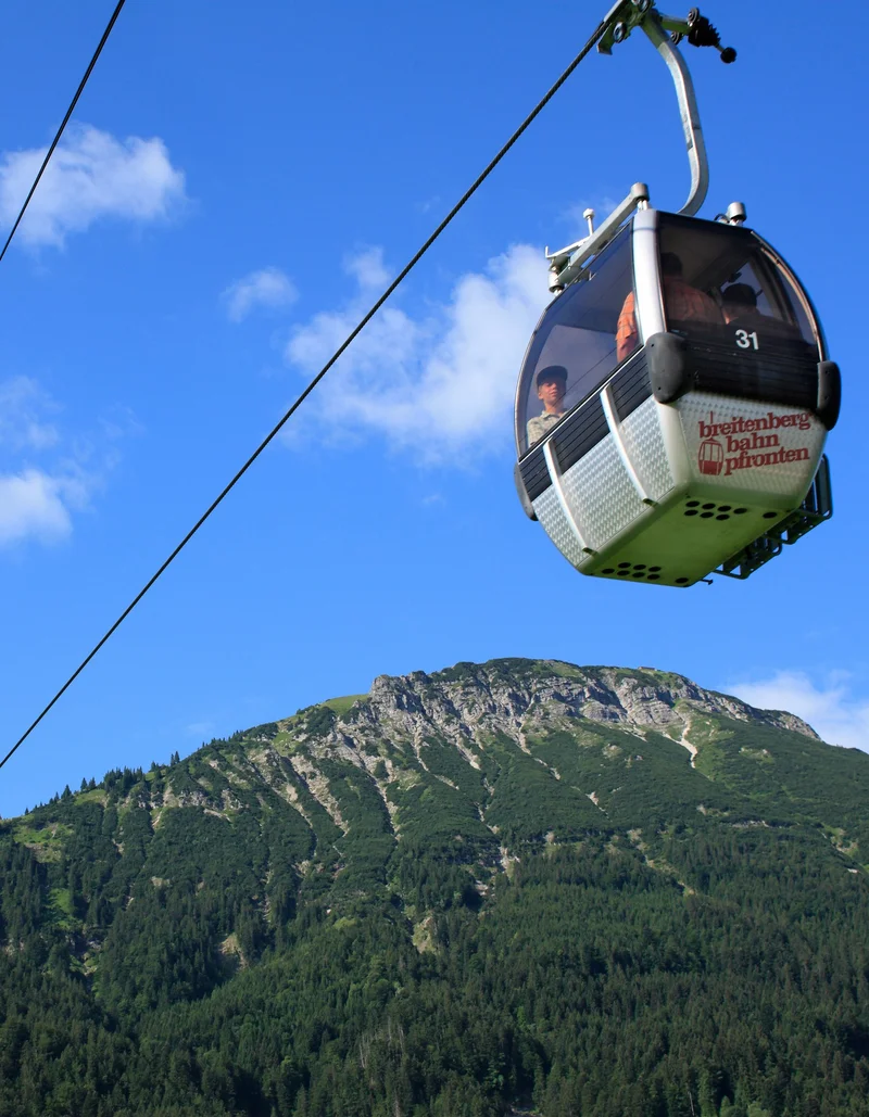 Eine Bergbahn befördert Gäste bei sonnigem Wetter auf den Breitenberg in Pfronten.