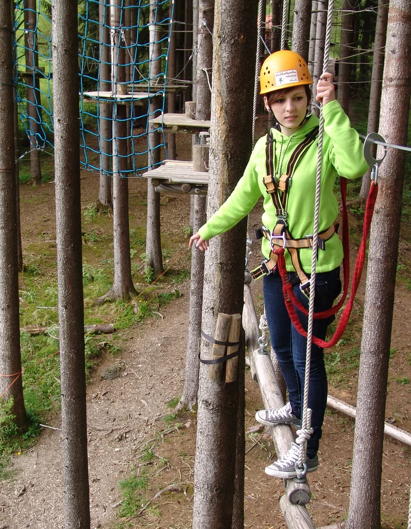 Eine Kletterin im Waldseilgarten Höllschlucht in Pfronten.