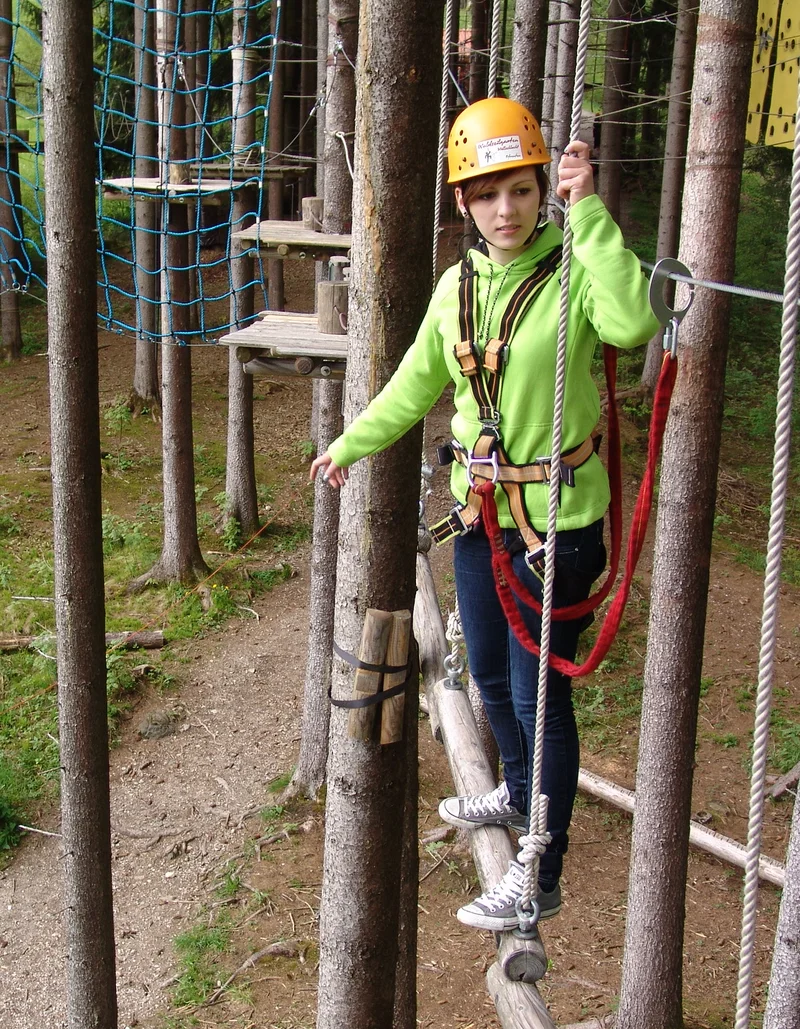 Eine Kletterin im Waldseilgarten Höllschlucht in Pfronten.