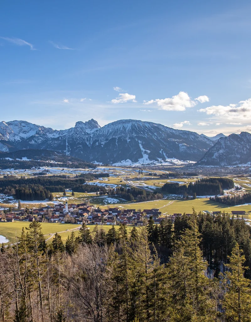 Letzte Schneereste im Tal Panoramablick auf das frühlingshafte Pfronten und die schneebedeckte Bergwelt.