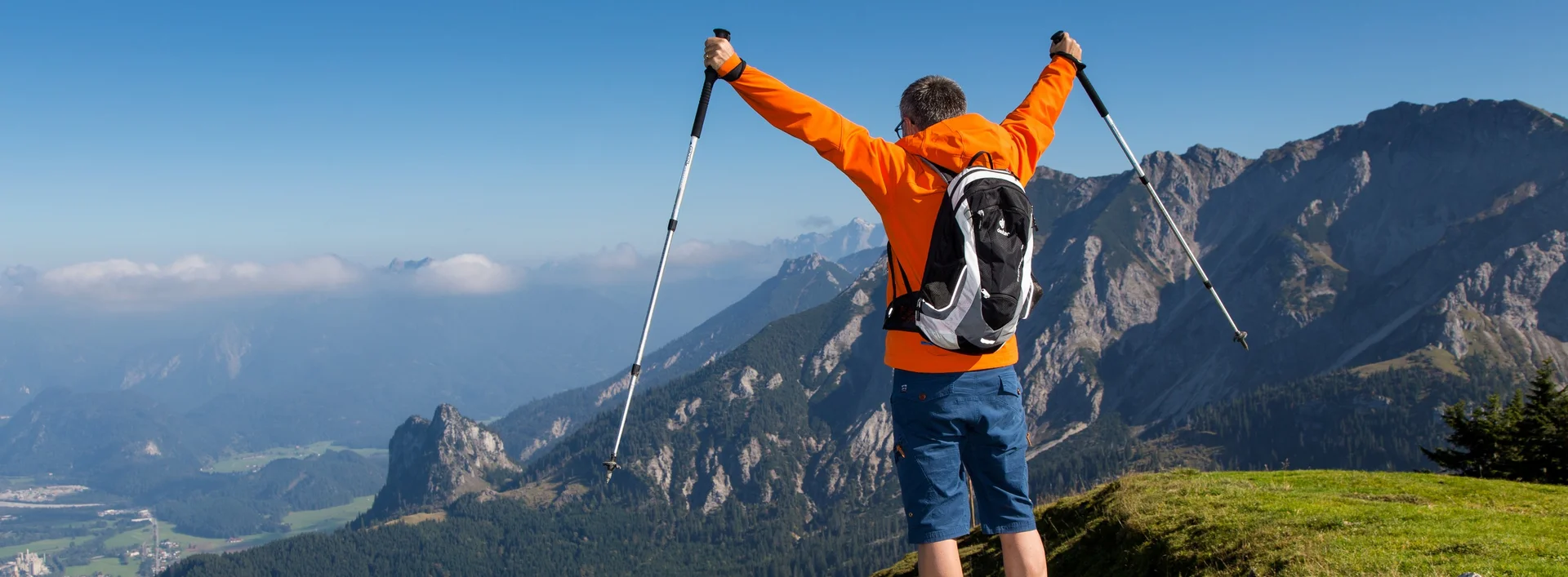 Ein Wanderer steht vor einer beeindruckenden Bergkulisse.
