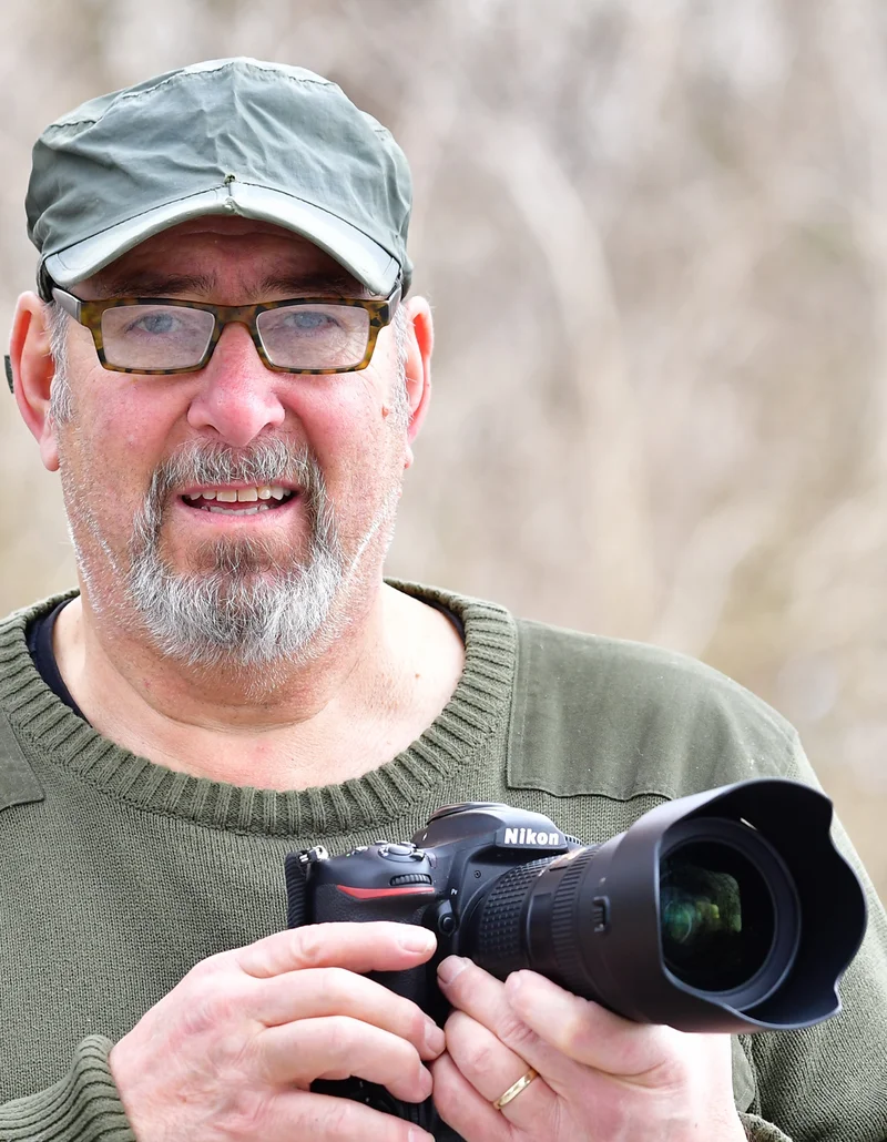 Ein Naturfotograf hält seine Kamera in der Hand.
