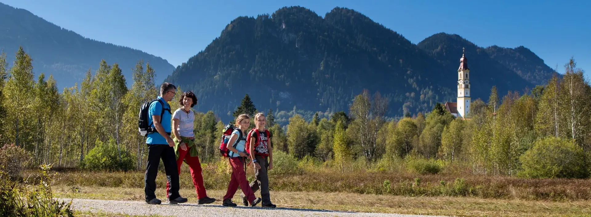 Spaziergang mit der Familie durch das Pfrontener Tal Eine Familie beim Spaziergang durch das sonnige Pfrontener Tal.