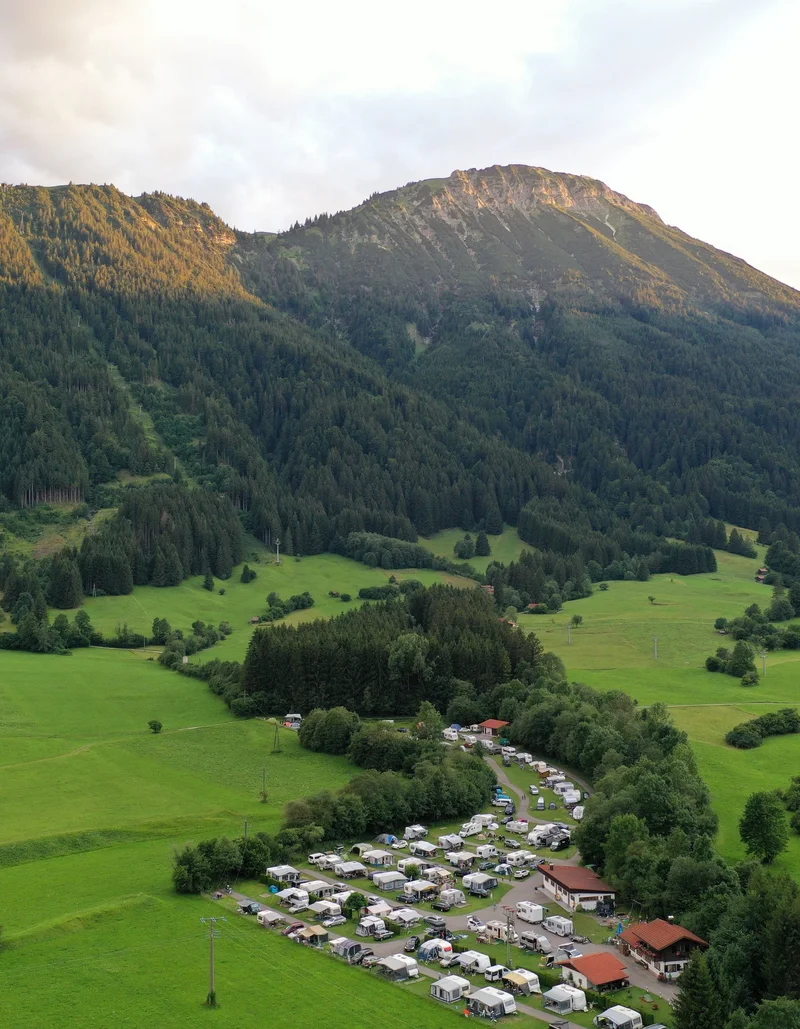 Schöner Blick von oben auf den idyllischen Campingplatz in Pfronten mit Bergen im Hintergrund.