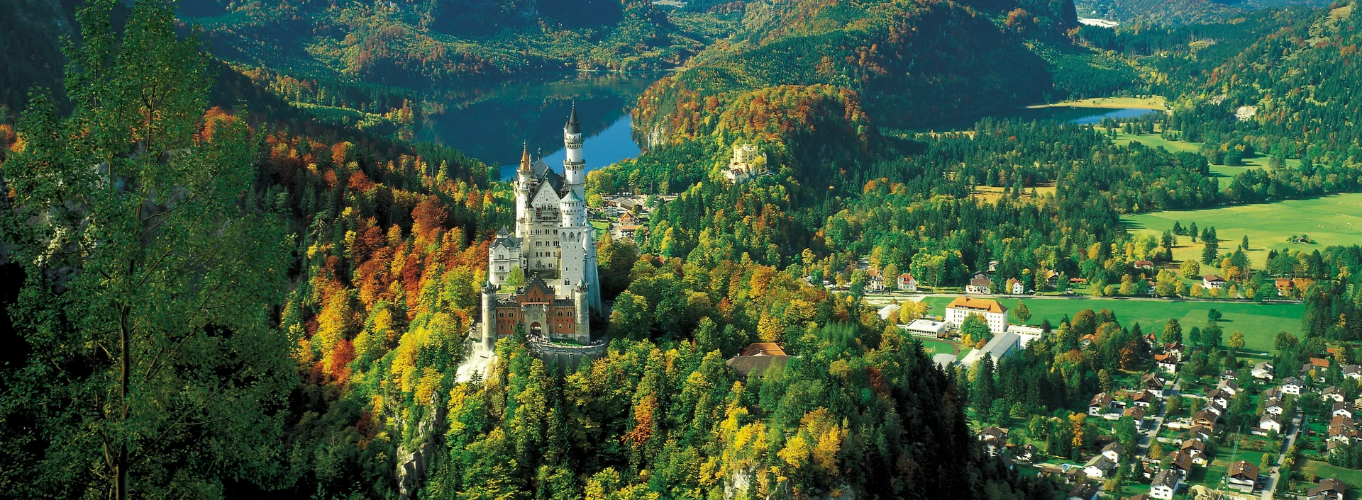 Schloss Neuschwanstein im Allgäu Panoramablick auf das Schloss Neuschwanstein im Allgäu und die umliegende Bergkulisse.
