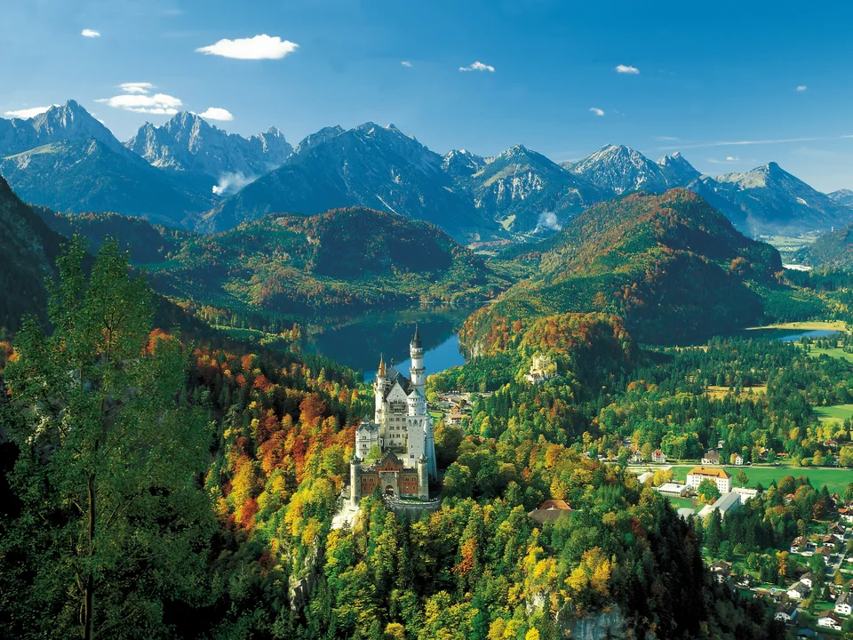 Schloss Neuschwanstein im Allgäu Panoramablick auf das Schloss Neuschwanstein im Allgäu und die umliegende Bergkulisse.