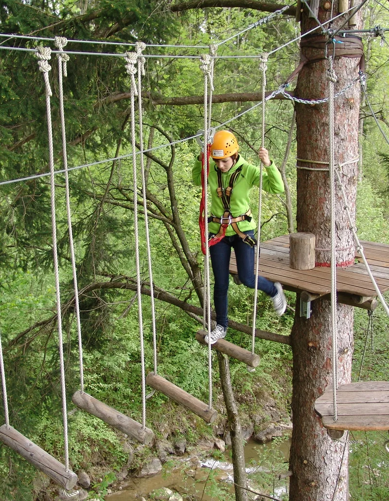Kletterspaß im Waldseilgarten Höllschlucht Eine Kletterin im Waldseilgarten Höllschlucht in Pfronten.