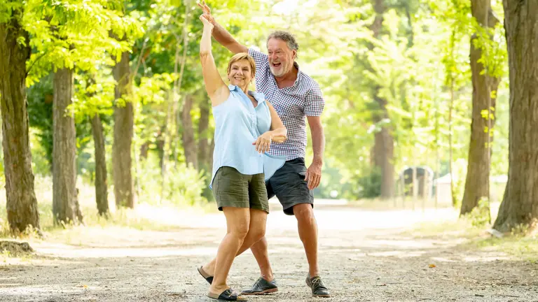 Tanzen im Kurpark Zwei Personen tanzen in einer grünen Umgebung.