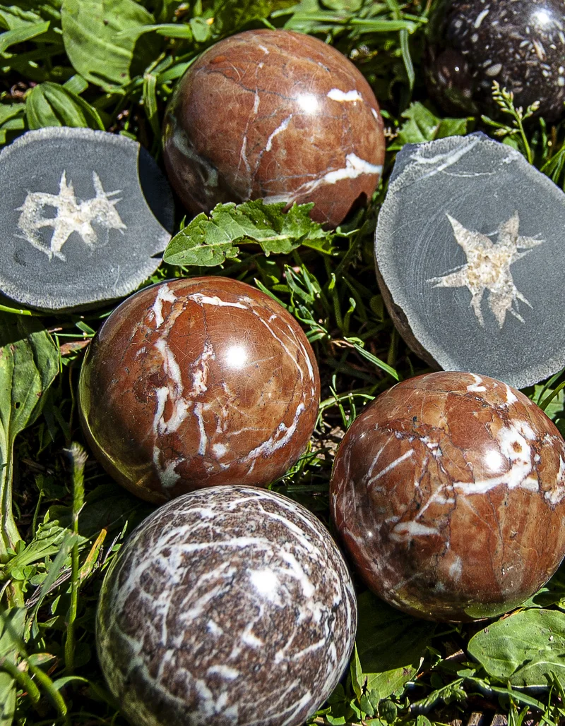 Steinkugelmühle in Pfronten im Allgäu Kugeln aus Stein liegen auf einer grünen Wiese.
