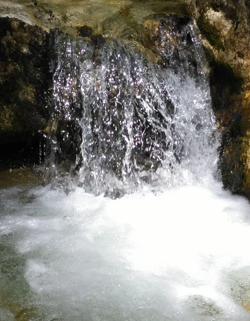 Wildnis Survival Wochenende ©A. Grotz Ein kleiner Wasserfall, der von einer Steinmauer herabfließt