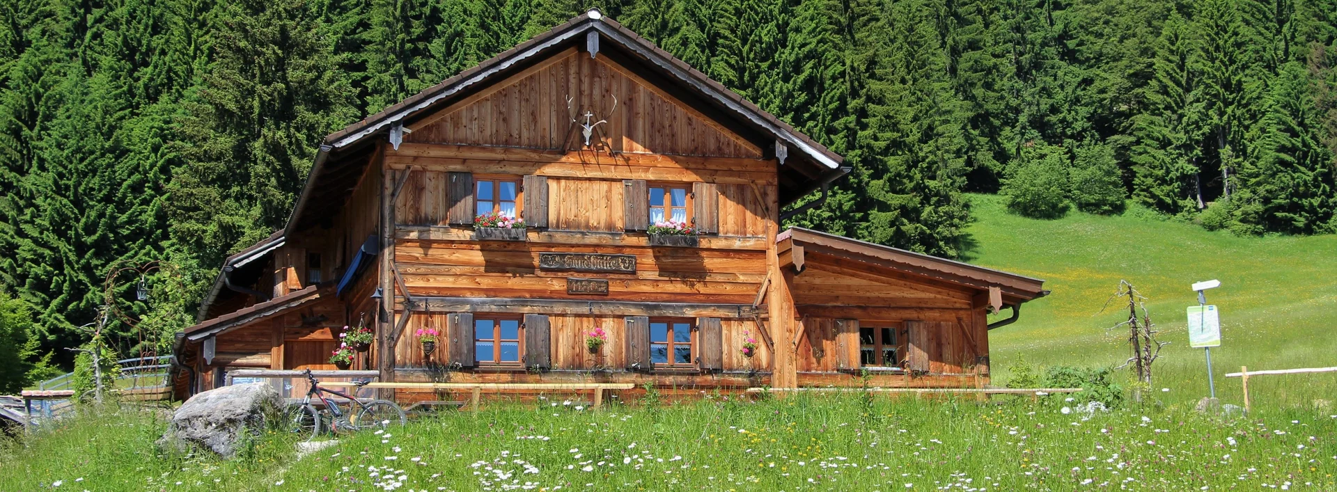 Edelsberghütte am Edelsberg - Wandern in den Allgäuer Alpen Sommerliche Sicht auf grüne Wiesen und die Edelsberghütte in Pfronten.