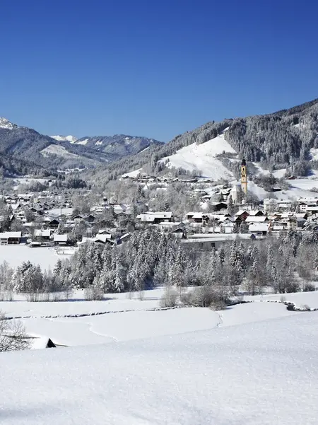 Panoramablick über das verschneite Pfrontener Tal mit beeindruckender Bergkulisse.