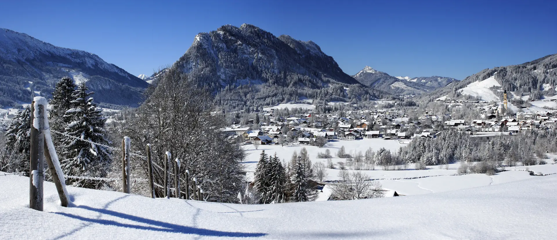 Panoramablick über das verschneite Pfrontener Tal mit beeindruckender Bergkulisse.