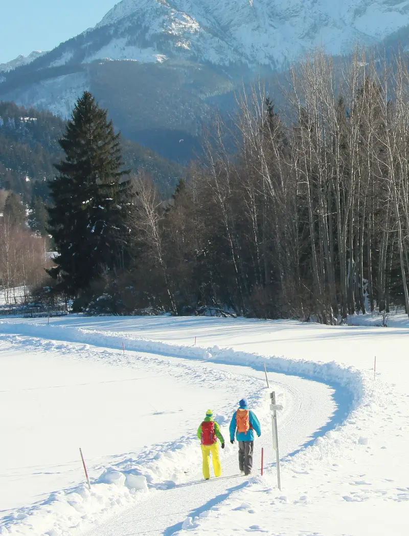 Geführte Wanderungen Winterwanderer in einer zauberhaften Schneelandschaft im Pfrontener Tal inmitten der verschneiten Bergwelt.