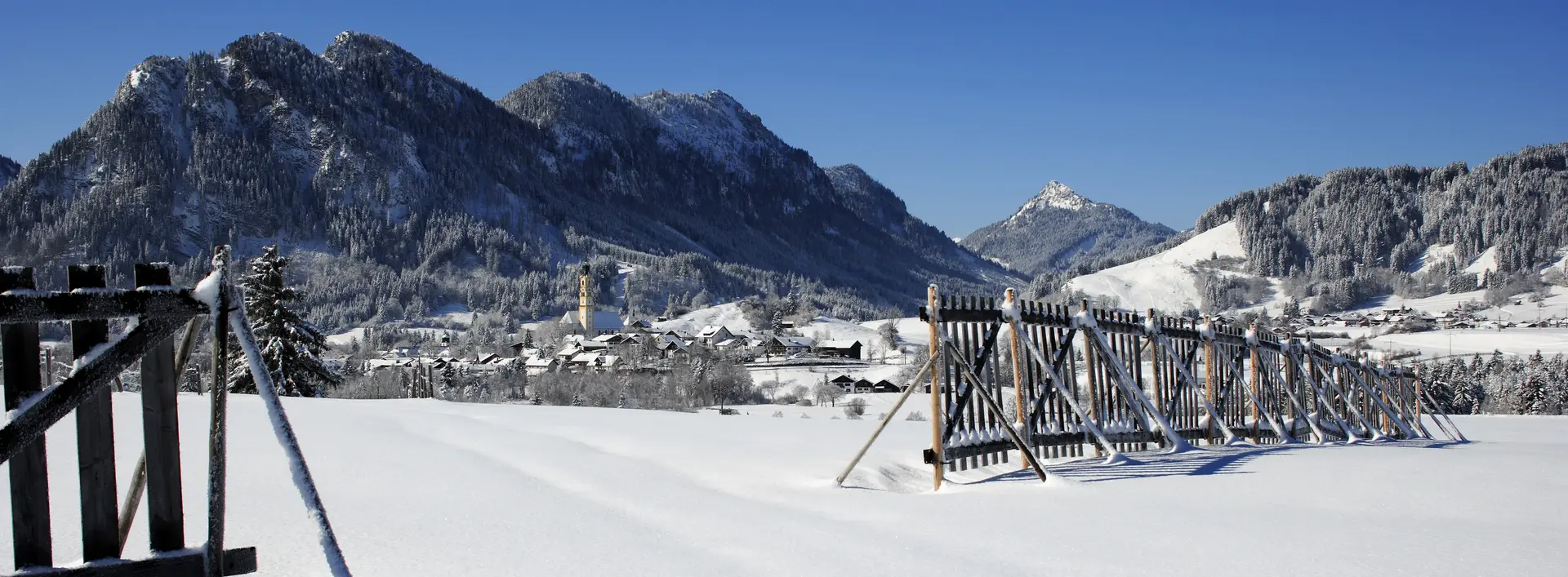 Das verschneite Pfrontener Tal mit Sonnenschein.