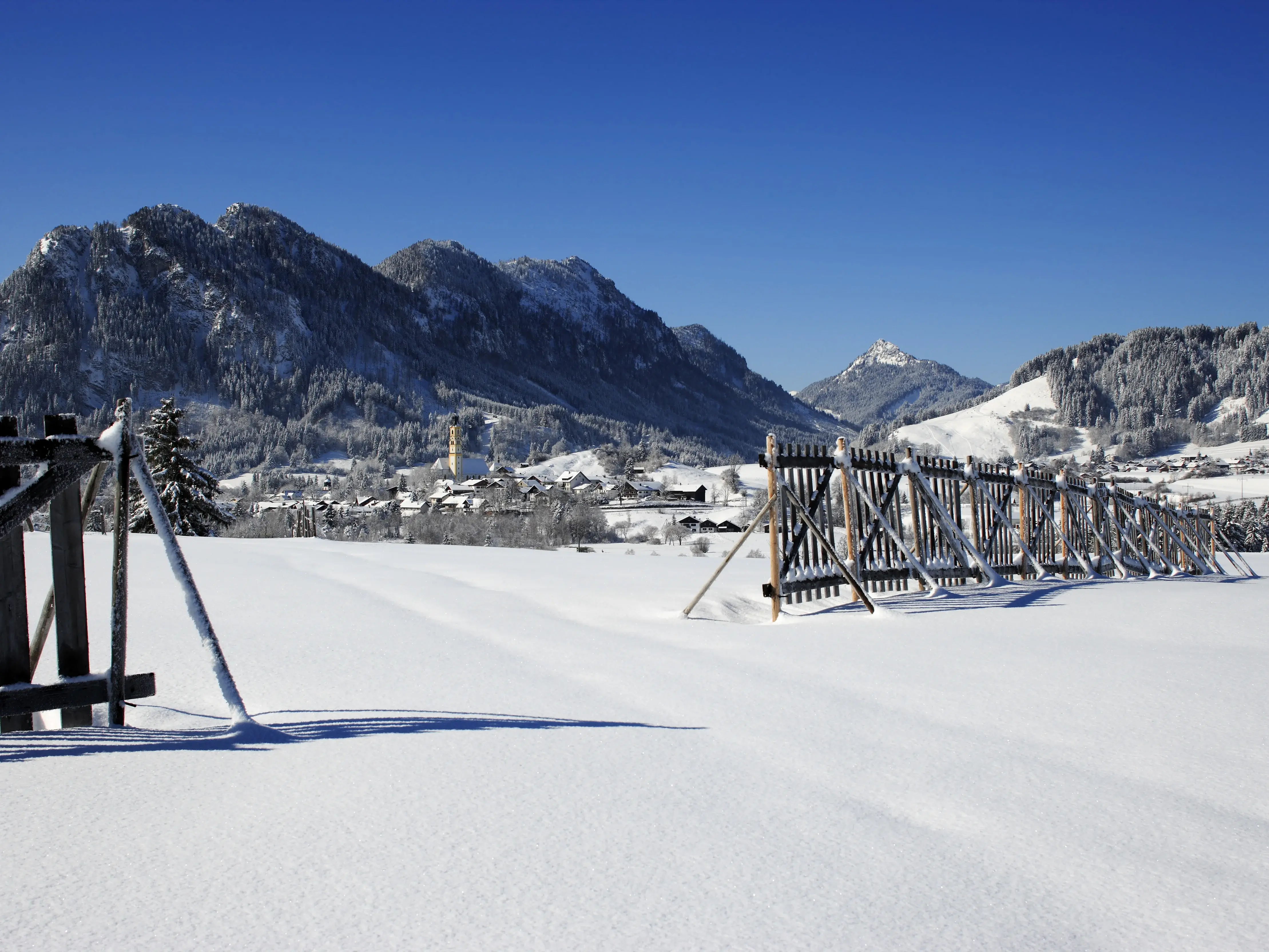 Das verschneite Pfrontener Tal mit Sonnenschein.