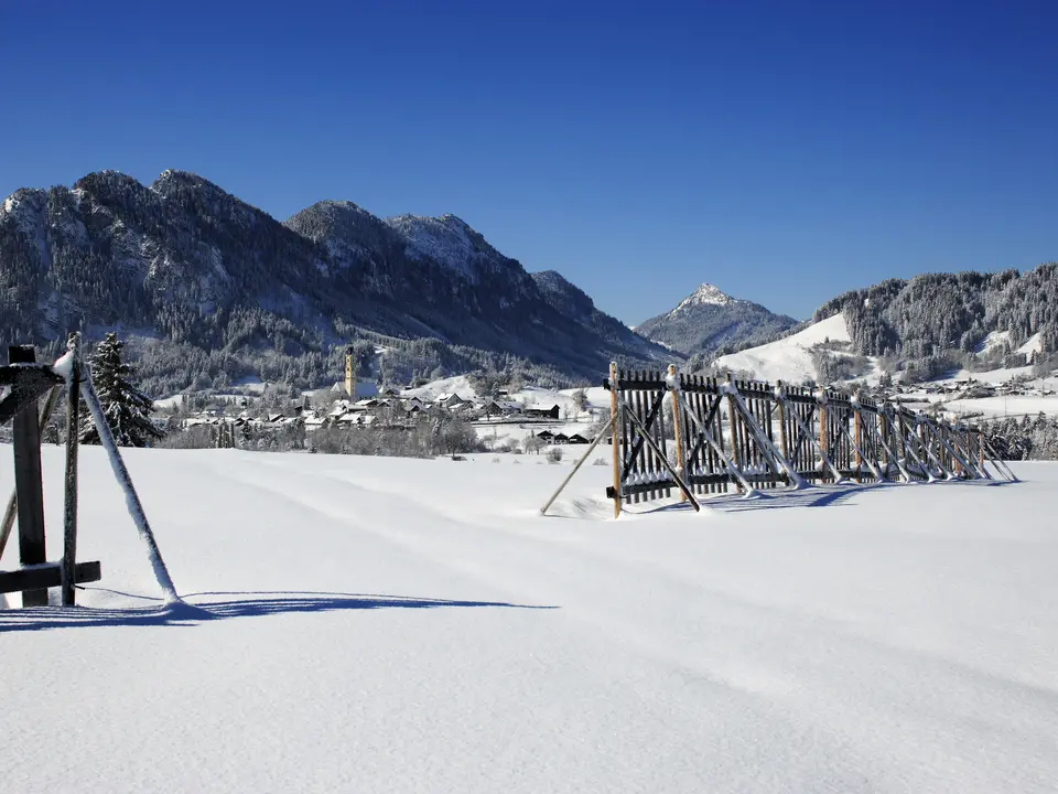 Das verschneite Pfrontener Tal mit Sonnenschein.