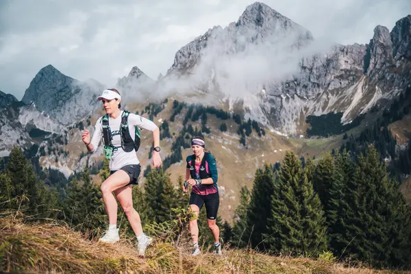 Zwei Trailrunnerinnen in einer imposanten Bergkulisse.