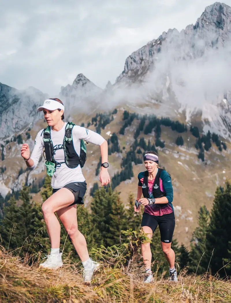 Zwei Trailrunnerinnen in einer imposanten Bergkulisse.