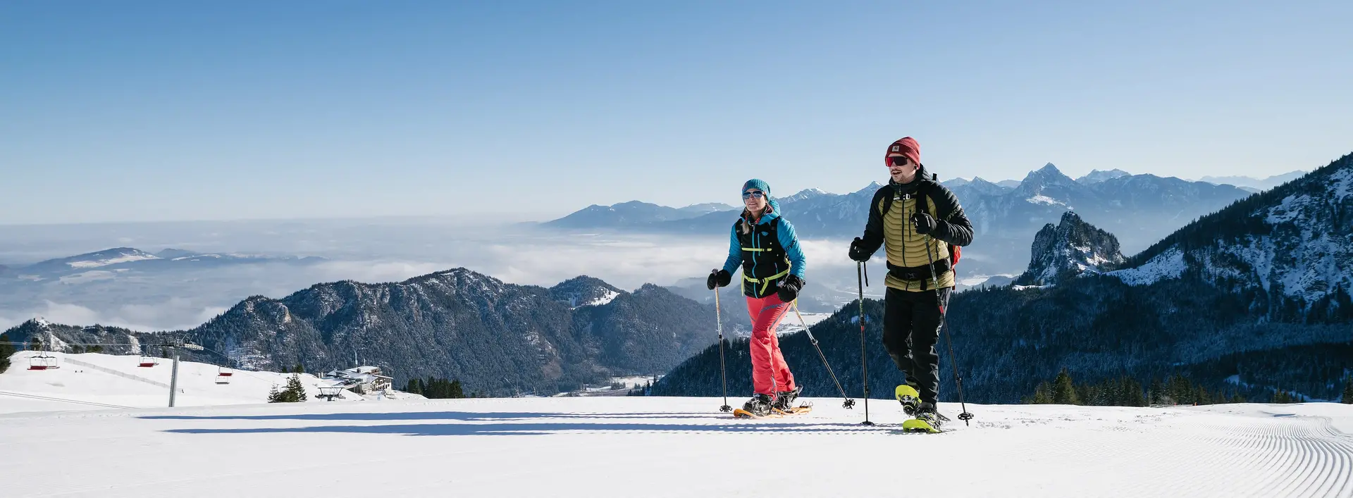 Schneeschuhwanderer in einer sonnigen Winterlandschaft am Breitenberg mit Blick auf die beeindruckende Berglandschaft.