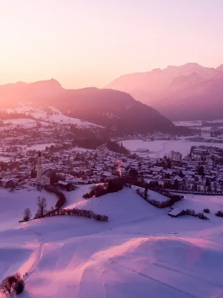 Den Allgäuer Winter in Pfronten genießen Malerischer Panoramablick auf das idyllisch verschneite Pfrontener Tal bei einem magischen Farbenspiel der Sonne.