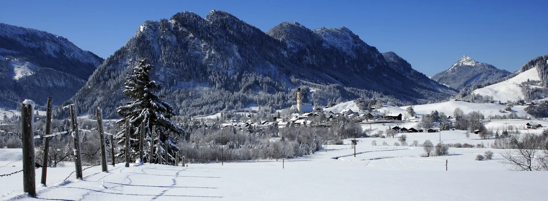 Eine zauberhafte Schneelandschaft im Pfrontener Tal inmitten der verschneiten Bergwelt.